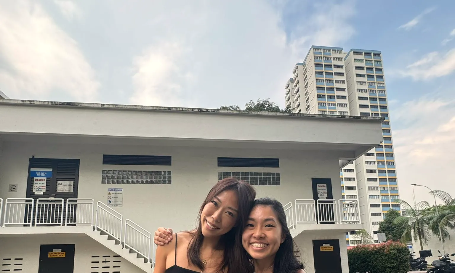 A hug with a client outside an Ang Mo Kio HDB block, just after the closing.