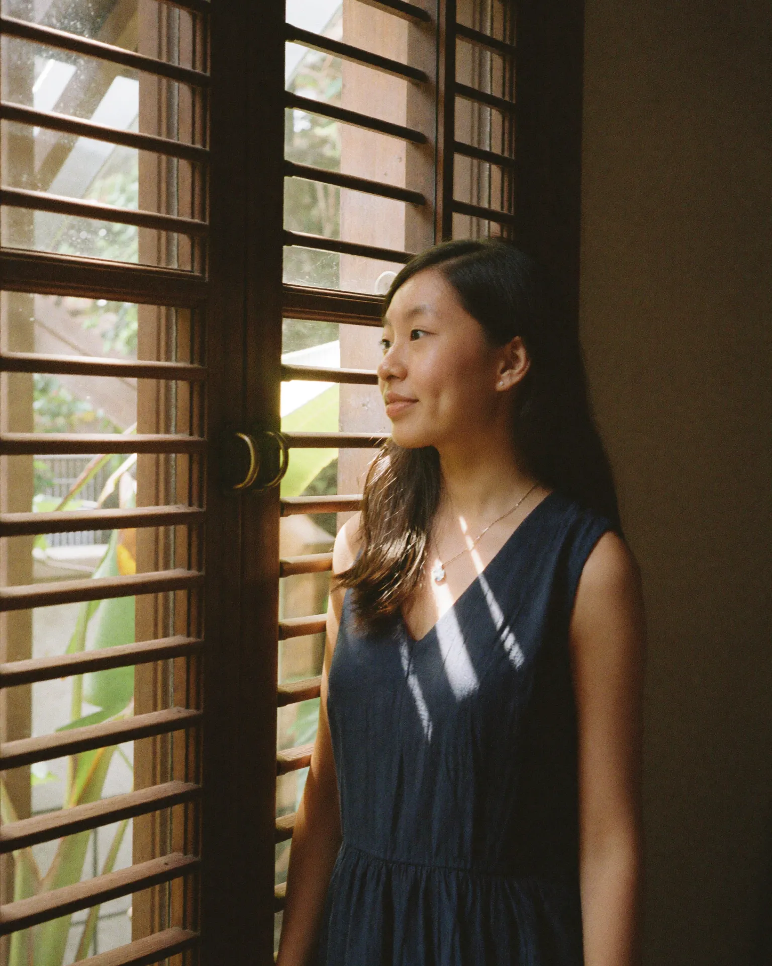 Jessin by a louvred window in soft morning light.